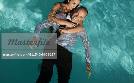 Fully dressed couple in swimming pool