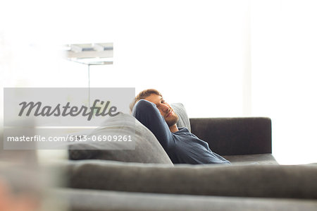 Smiling man relaxing on sofa