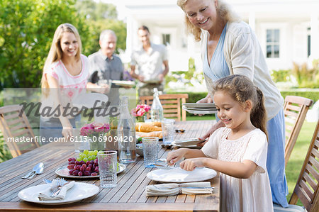 Family setting table outdoors