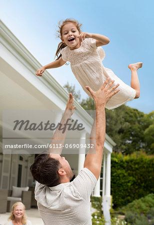 Father and daughter playing outside house Father and daughter playing outside house