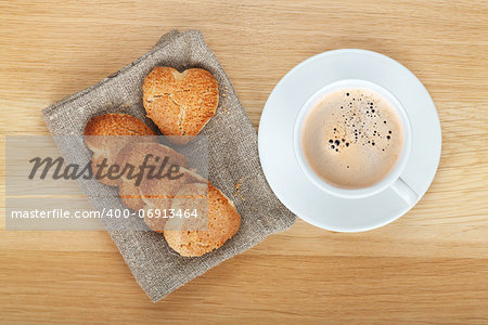 Coffee cup and cookies on wooden table. View from above