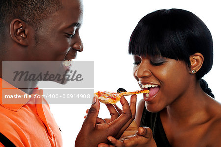 Beautiful african couple eating pizza isolated over white, closeup shot