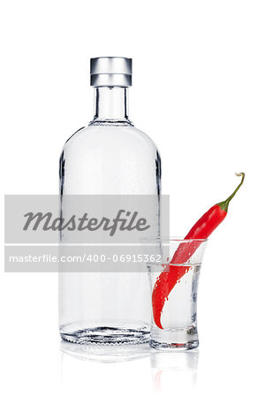 Bottle of vodka and shot glass with red chili pepper. Isolated on white background