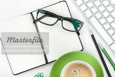 Coffee cup and office supplies. Closeup on white background