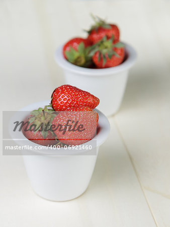 ripe strawberries in bowl, on wood table