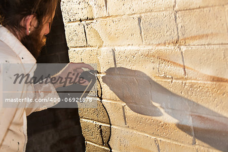 Caucasian graffit artist working on mural with spray paint