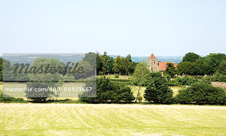 Rural landscape with mown fields and historic church in Kent, England