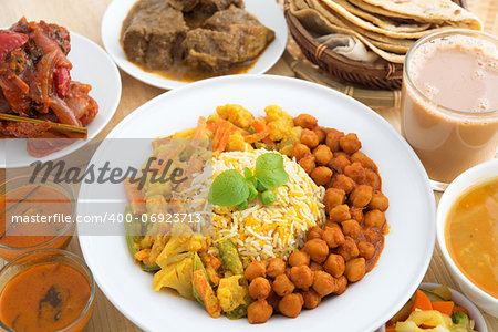 Indian food biryani rice, mutton curry, chapatti, milk tea, dal, salad and curry chicken. Indian dining table.