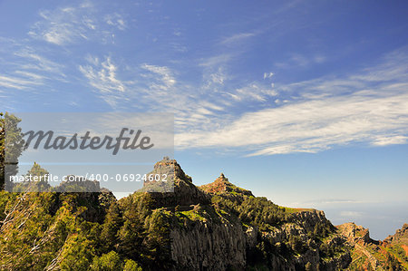 Beautiful clouds over the rocks covered in green vegetation, Spain La Gomera