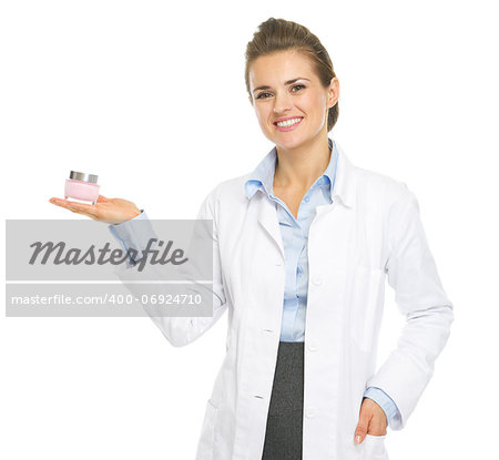 Smiling cosmetologist woman showing cream bottle