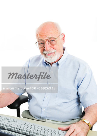 Senior man sitting at a desktop computer.  Isolated on white.