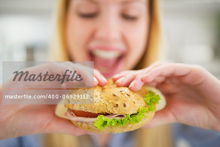 Closeup on happy young woman eating burger