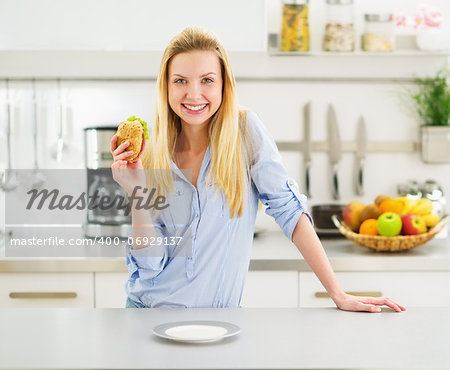 Happy teenager girl holding burger