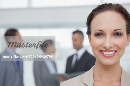 Cheerful businesswoman smiling at camera in bright office