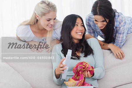 Woman looking thankful for present from her friends at home on couch