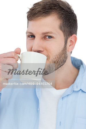 Casual young model on white background drinking a coffee