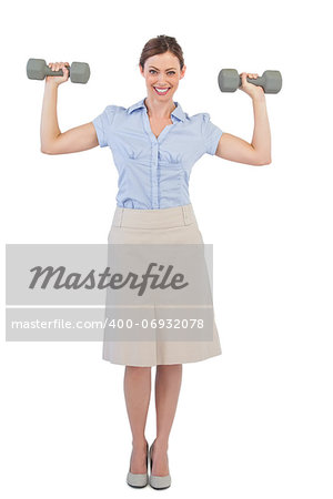 Strong businesswoman posing with dumbbells against white background