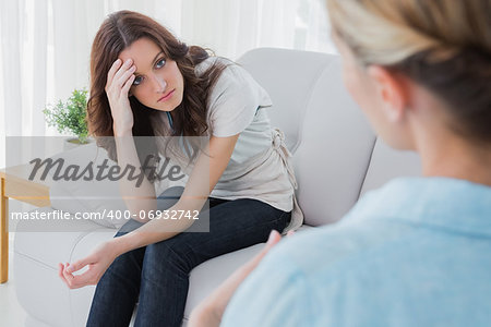 Worried woman sitting and looking at her therapist during a session