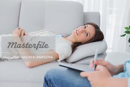 Pretty brunette lying on the couch with therapist listening