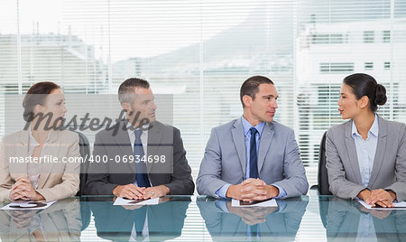 Business people sitting straight talking together in bright office
