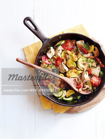 Overhead View of Chicken and Mushroom Ratatouille in Cast Iron Skillet with Wooden Spoon, Studio Shot