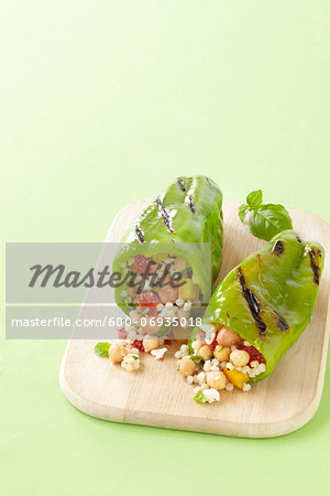 Grilled Green Peppers Stuffed with Israeli Couscous, Chickpeas and Vegetables on Cutting Board, Studio Shot Grilled Green Peppers Stuffed with Israeli Couscous, Chickpeas and Vegetables on Cutting Board, Studio Shot