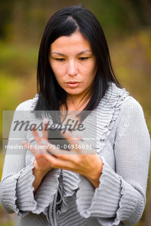Young woman using a smart phone to send a text message, Ontario, Canada