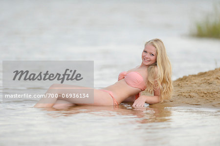 Young woman swimming in a little lake in summer, Bavaria, Germany.