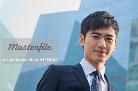 Portrait of young businessman outside glass building