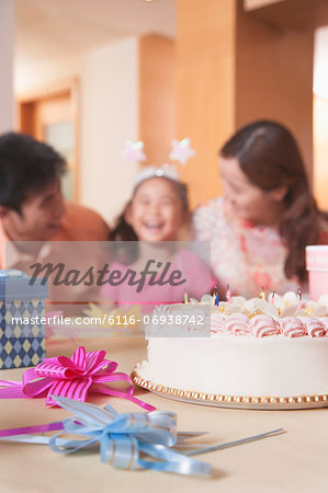 Family Celebrating Girl's Birthday - Focus On Birthday Cake