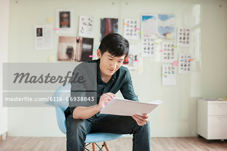 Professional Man Looking at Papers in Office Professional Man Looking at Papers in Office