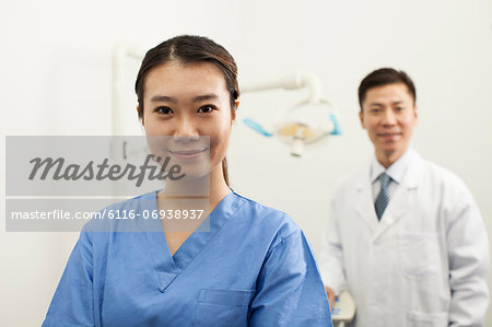 Portrait Of Smiling Female Dental Assistant In Clinic