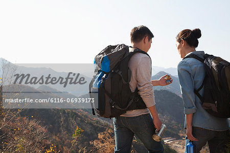 Young couple hiking and looking at the compass