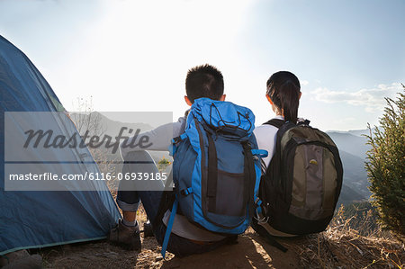 Young couple sitting next to the tent