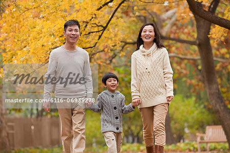 Family walking through the park in the autumn