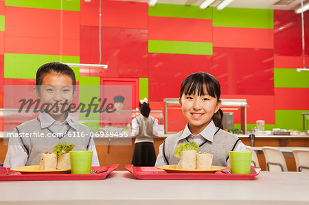 Two girls sitting in school cafeteria