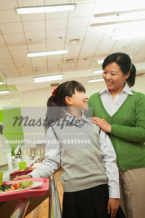 Teacher and school girl portrait in school cafeteria