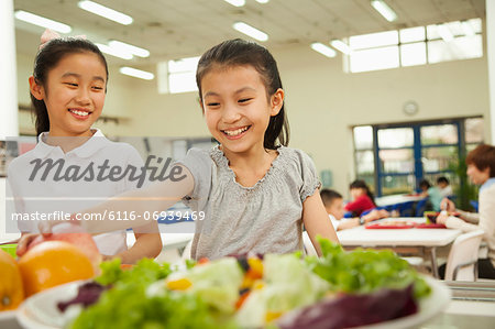 Students reaching for healthy food in school cafeteria