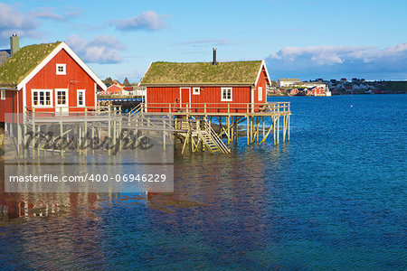 Typical red rorbu huts with sod roof in town of Reine on Lofoten islands in Norway