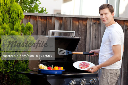 handsome young man ready for grilling meat and vegetables