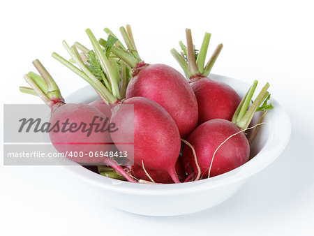 heap of ripe radishes in plate, isolated on white background
