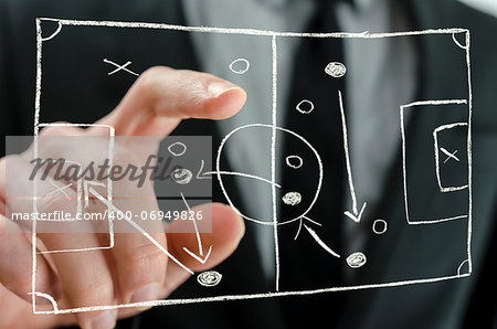 Closeup of coach pointing to a football strategy plan drawn on a virtual screen.