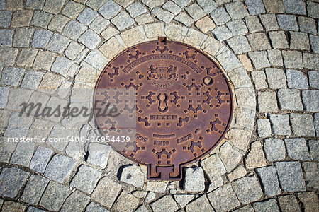 Budapest rusted sewer cap surrounded by pavement granite stones