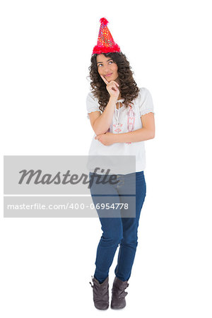 Pensive casual brunette with party hat posing on white background