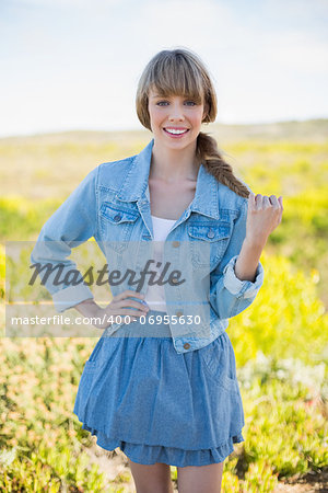 Smiling trendy young woman posing in a sunny arid land