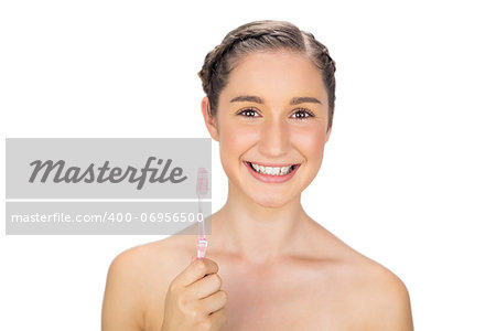 Cheerful young model on white background holding toothbrush