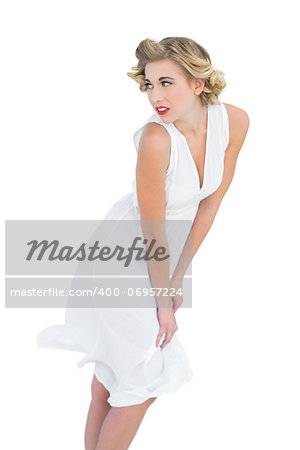 Thoughtful fashion blonde model posing looking away on white background
