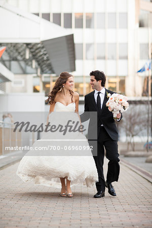 Bride and Groom walking towards camera along walkway in City Park on Wedding Day, Toronto, Ontario, Canada