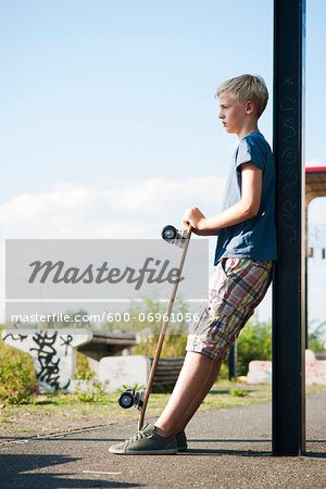 Portrait of boy outdoors with skateboard, standing on street, Germany Portrait of boy outdoors with skateboard, standing on street, Germany