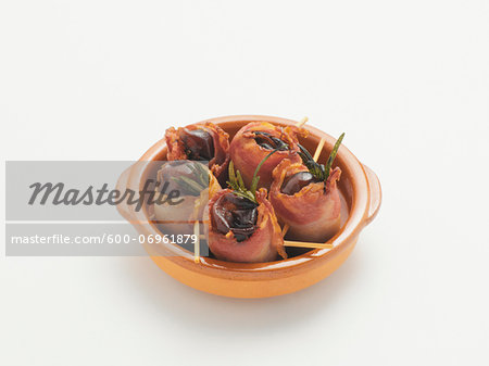 Dates Wrapped with Bacon on White Background, Studio Shot